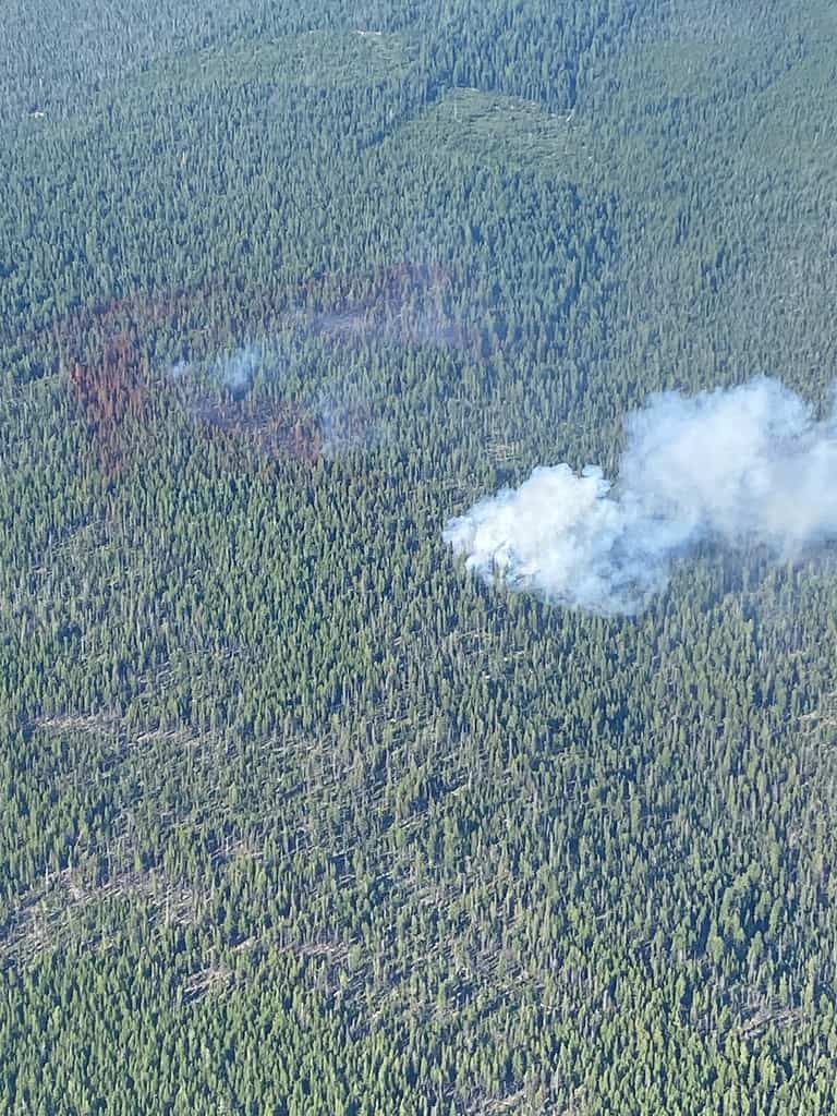 Smoke from Tolo Fire area is wispy. Fire area surrounded by retardant. Heavier smoke off of the main fire is a new spot fire.