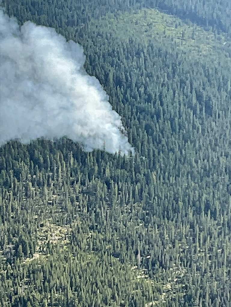 Tolo Mountain Fire as seen from the air. Smoke column coming out of thick timber.